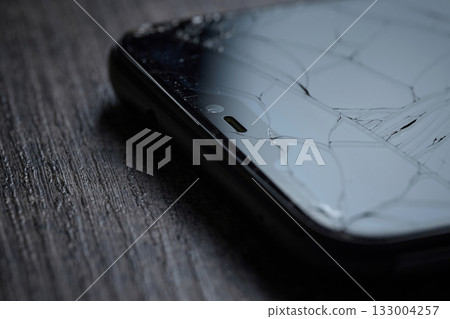 A close-up view of a cracked smartphone screen. High quality photo A close-up view of a cracked smartphone screen. High quality photo 133004257