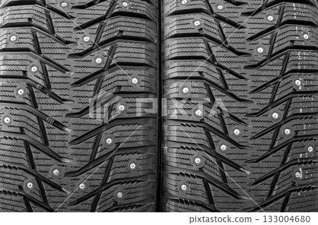 Close-up texture of studded winter tire tread pattern designed for traction on icy and snowy roads 133004680