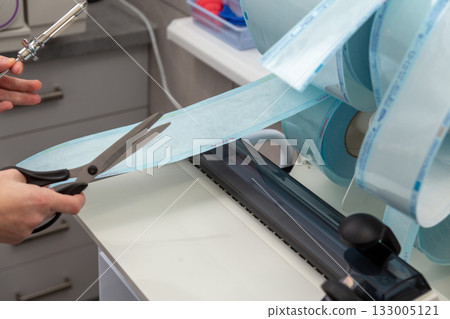 A medical professional uses a constant heat sealing machine to create sterilization pouches 133005121