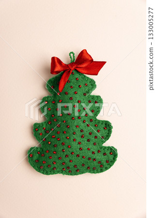 Handmade Felt Christmas Tree Ornaments with Bows on Pink Background Handmade Felt Christmas Tree Ornaments with Bows on Pink Background 133005277
