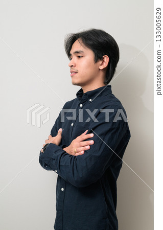 Portrait of handsome Young Asian Thai man profile with arms crossed against white background 133005629