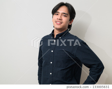 Portrait of handsome Young Asian Thai man smiling against white background 133005631