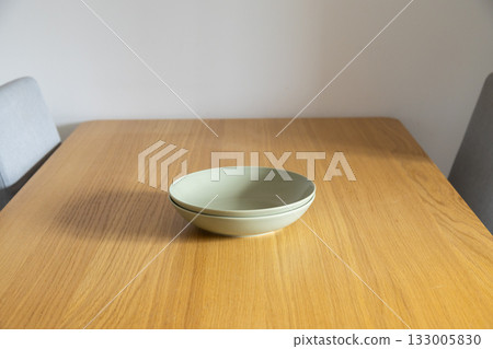 Two green bowls on wooden table. Everyday tranquility, warmth, and minimalist aesthetic in home dining. Copy space 133005830