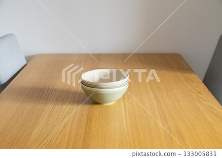 Minimal stack of bowls centered on table. Order, lightness, and quiet aesthetic of Scandinavian home. Copy space Minimal stack of bowls centered on table. Order, lightness, and quiet aesthetic of Scandinavian home. Copy space 133005831