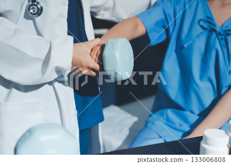 Physical therapist assisting a woman with dumbbell exercise Physical therapist assisting a woman with dumbbell exercise 133006808