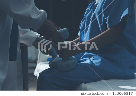 Physical therapist assisting a woman with dumbbell exercise Physical therapist assisting a woman with dumbbell exercise 133006817