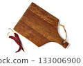 Brown wooden cutting board and two hot red peppers isolated on white background. 133006900