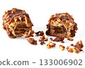 Close-up of a broken wafer caramel bar with nuts in chocolate glaze on a white background/ 133006902