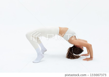 Fitness pose showcase, Elegant woman balances gracefully, Athlete demonstrating flexibility and strength wih focus, Dancer in white attire performing bridge with poise Fitness pose showcase, Elegant woman balances gracefully, Athlete demonstrating flexibility and strength wih focus, Dancer in white attire performing bridge with poise 133007373