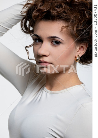 An Elegant and Captivating Portrait of a Woman with Beautiful Curly Hair in a Stylish Outfit 133007431