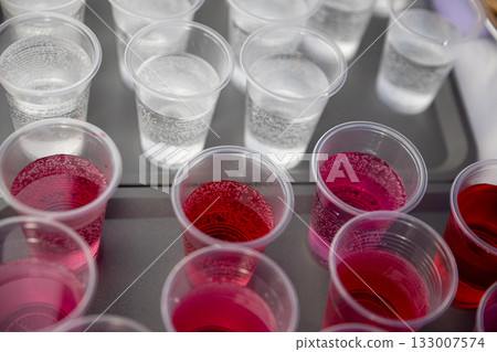 A Variety of Colorful Party Drinks Served in Plastic Cups on a Tray for Everyone to Enjoy A Variety of Colorful Party Drinks Served in Plastic Cups on a Tray for Everyone to Enjoy 133007574