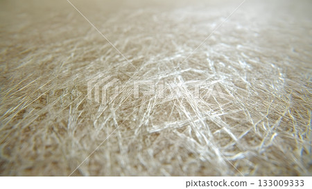 Macro shot of a light gold shiny abstract background with dense, intersecting fibers or scratches. Features strong depth of field and beautiful light reflection. AI Generated 133009333