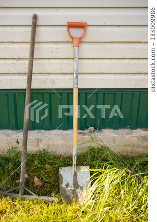 Garden tools by green house wall sunny country yard Garden tools by green house wall sunny country yard 133009986