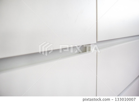 White dresser drawer fronts minimal interior close up White dresser drawer fronts minimal interior close up 133010007