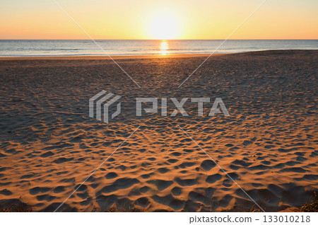 Sandy beach lit by the morning sun Sandy beach lit by the morning sun 133010218