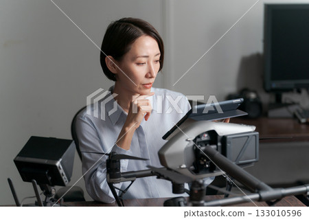 一名女子正在檢查無人機的運作情況。 133010596