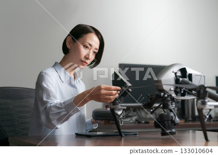 A woman checking the operation of a drone 133010604