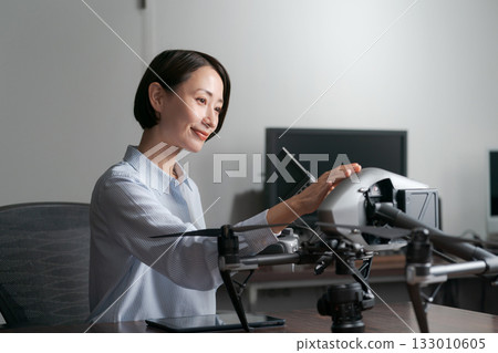 A woman checking the operation of a drone 133010605