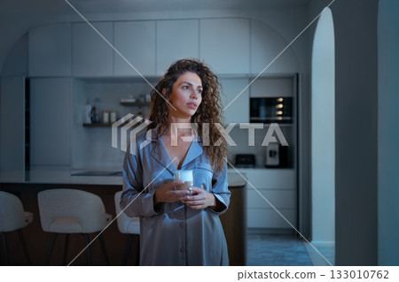 Young woman in pajamas having coffee in modern Young woman in pajamas having coffee in modern 133010762