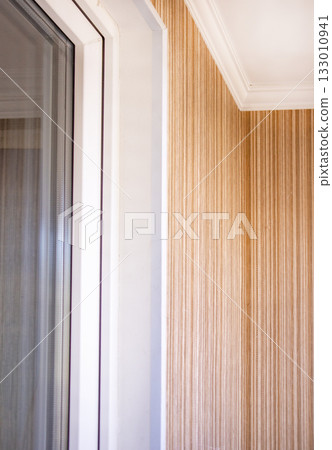 Interior corner with white window frame and striped wallpaper close up Interior corner with white window frame and striped wallpaper close up 133010941