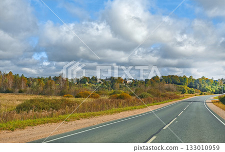 Country road through fields and forest cloudy day freedom of the road horizontal frame 133010959