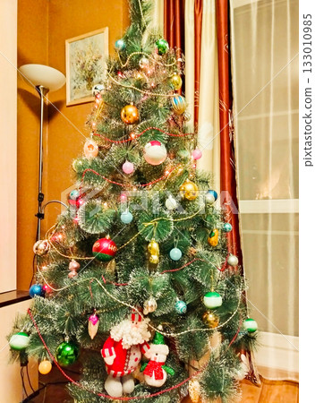 Decorated Christmas tree at home with ornaments and garland cozy interior vertical frame 133010985