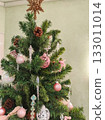 Christmas tree top with pink ornaments and pinecones close up 133011014