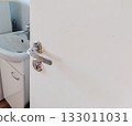 White door with chrome handle and lock view to bathroom sink 133011031