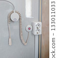 Vertical close up of a nurse call panel and outlet in a hospital room 133011033