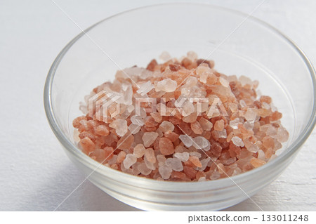 Pink rock salt in a glass container 133011248