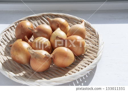 Small onions drying on a windowsill in winter Small onions drying on a windowsill in winter 133011331