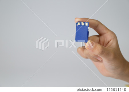 Hand holding a blue SD card Hand holding a blue SD card 133011348