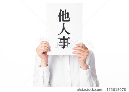 一個穿著白襯衫的人雙手拿著一張紙，上面寫著「別人的事」。 133012078