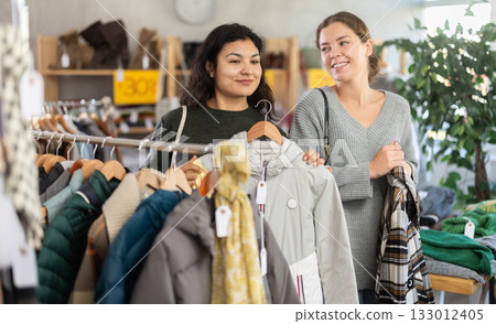 Two women choosing jackets in a clothing store Two women choosing jackets in a clothing store 133012405