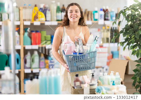 Young woman chooses household chemicals in store Young woman chooses household chemicals in store 133012417