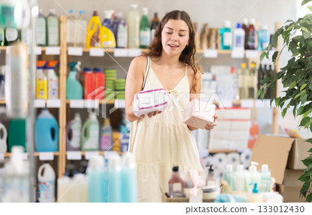 Young woman chooses feminine pads in store Young woman chooses feminine pads in store 133012430