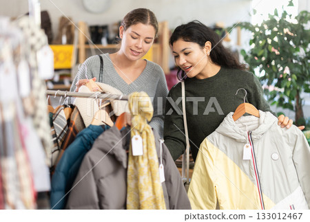 Two women choosing jackets in a clothing store Two women choosing jackets in a clothing store 133012467
