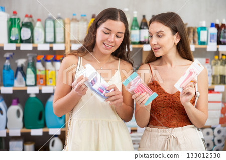 Young women discussing choice of razors in personal care store Young women discussing choice of razors in personal care store 133012530