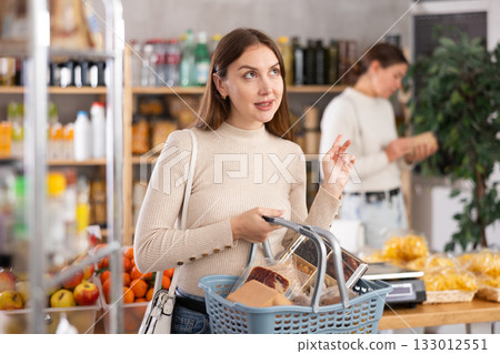Young woman choosing groceries in the supermarket Young woman choosing groceries in the supermarket 133012551