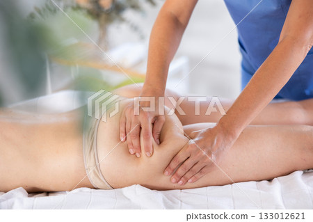 Woman gets intensive anti-cellulite massage Woman gets intensive anti-cellulite massage 133012621