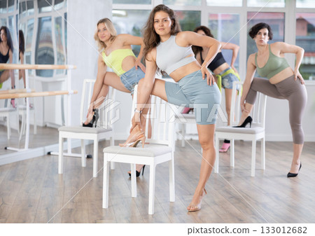 Putting foot hand on seat of chair, girl improvises, perform lap dance during group master class 133012682