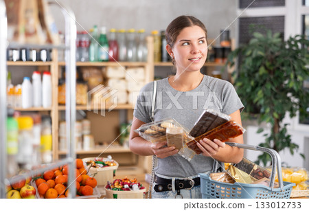 Young woman choosing sweets in grocery store Young woman choosing sweets in grocery store 133012733