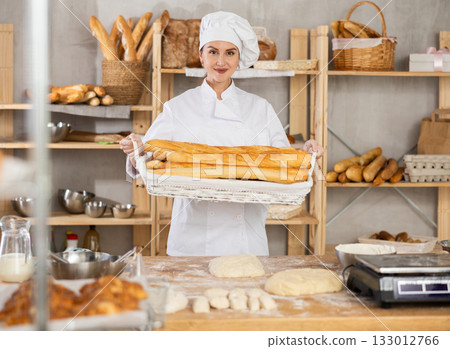 Positive female seller showing assortment of bakery 133012766