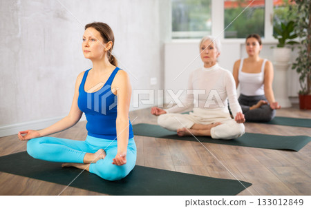 Adult woman doing yoga in fitness studio Adult woman doing yoga in fitness studio 133012849