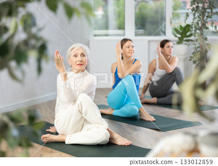 Elderly woman doing yoga in fitness studio Elderly woman doing yoga in fitness studio 133012859
