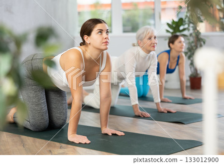 Young woman doing yoga in fitness studio 133012900