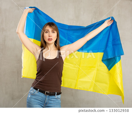 Young sad woman holding flag of Ukraine 133012938