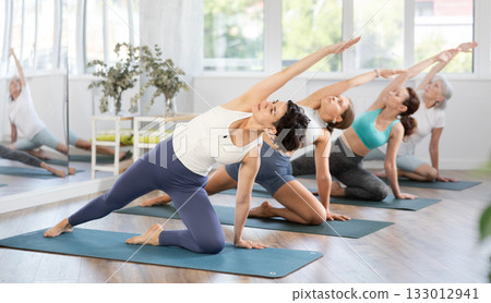 Adult woman doing pilates in group in studio Adult woman doing pilates in group in studio 133012941