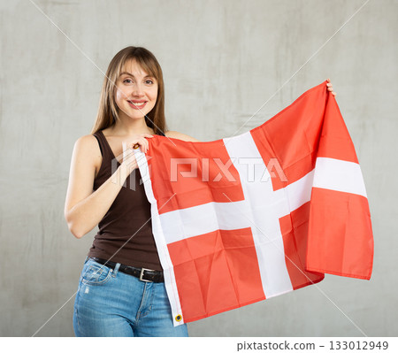 Young happy pretty woman displaying flag of denmark 133012949
