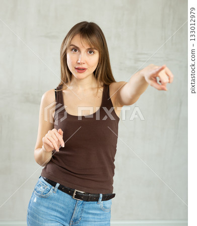 Smiling young woman gesturing in studio Smiling young woman gesturing in studio 133012979